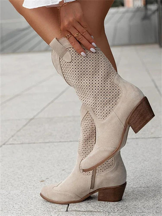 Beige knee-high boots with brown soles on a pavement background
