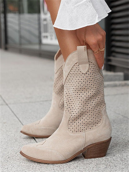Beige perforated ankle boots worn by a person on a city street