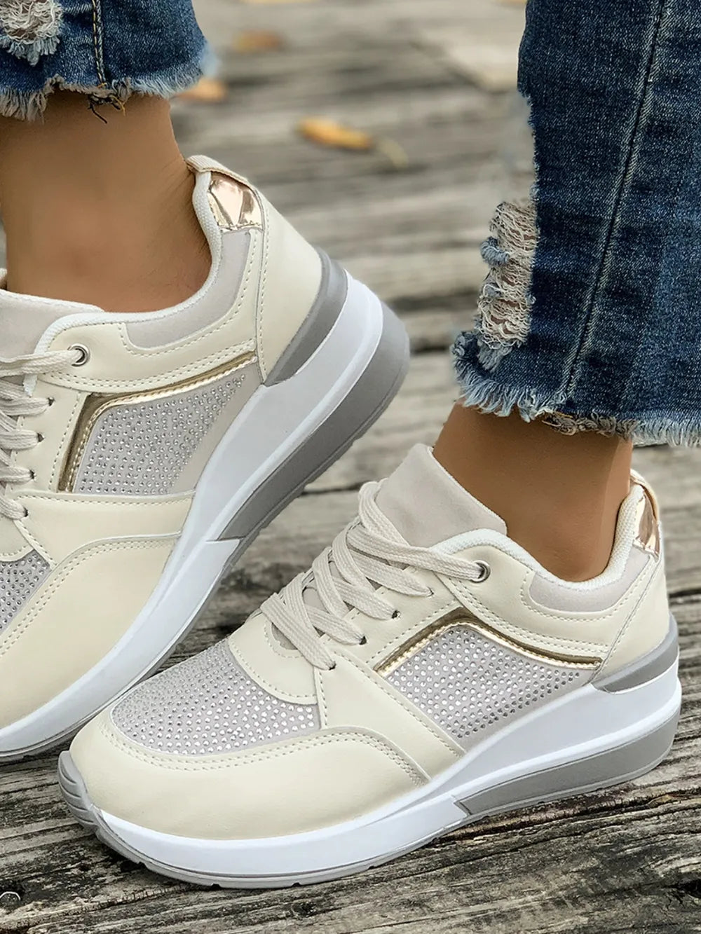Beige sneakers worn on a wooden floor