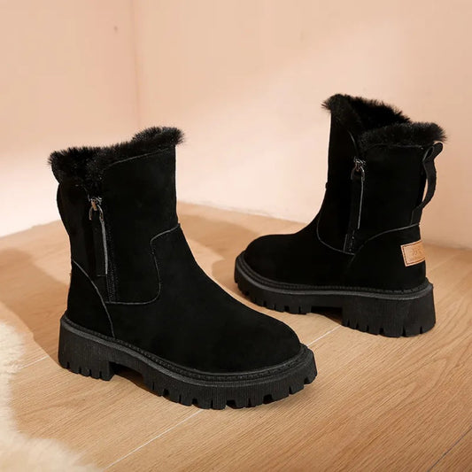 Black suede boots with fur trim on a wooden floor