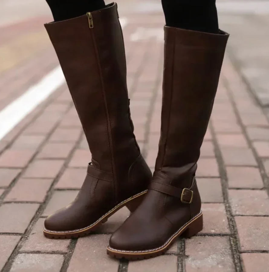 Brown knee-high boots on a brick pavement