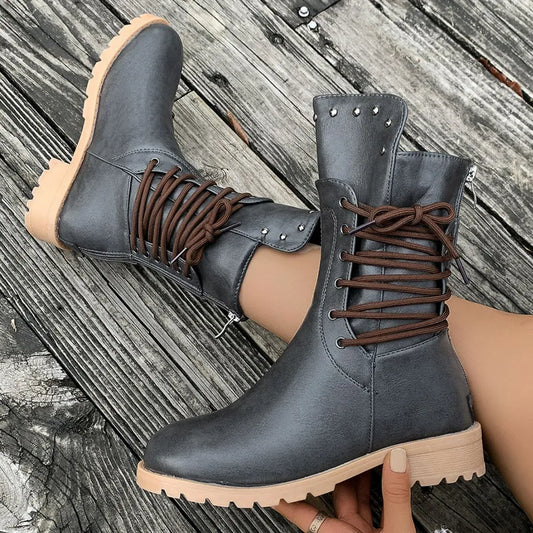 Gray boots with brown laces on a wooden floor