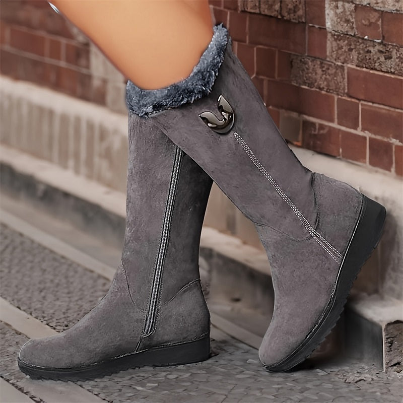 Gray knee-high boots with fur lining worn by a person on a stone step