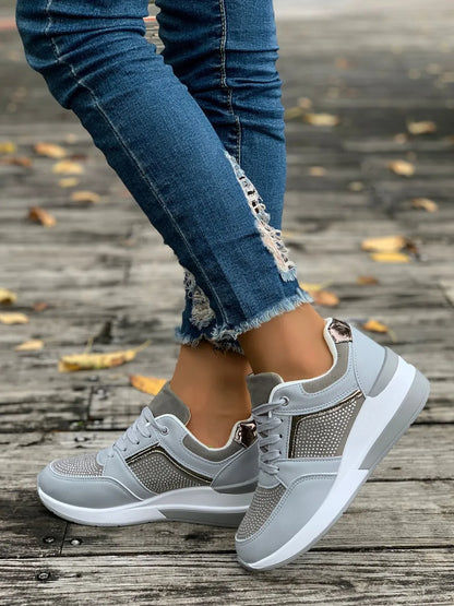 Gray sneakers worn with ripped jeans on a wooden floor