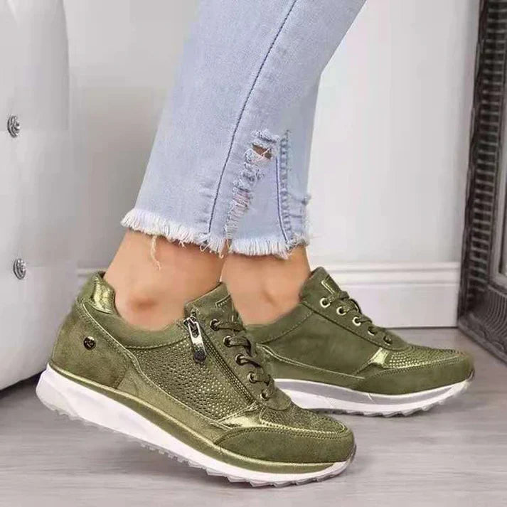 Green sneakers worn with light blue jeans on a neutral background